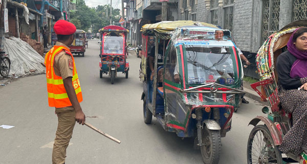 মাদারীপুরের রাস্তায় ট্রাফিকের দায়িত্ব পালন করছে শিক্ষার্থীরা